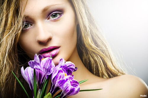 Woman staring intensely and holding purple flowers