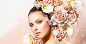 Woman with glowing skin and her head surrounded by white and pink flowers