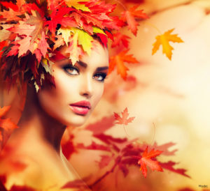 Woman with autumn leaves on her head staring intensely