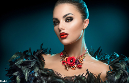 Woman in dark eye makeup wearing a flowery necklace and a feather boa