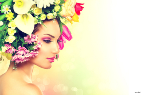 Woman in pink lipstick and eye makeup wearing a headdress of various flowers