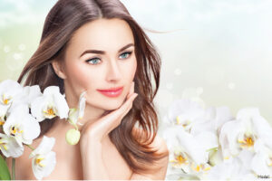 Serene woman smiling into the distance surrounded by white orchids