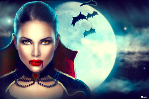 woman with vampire makeup in front of full moon